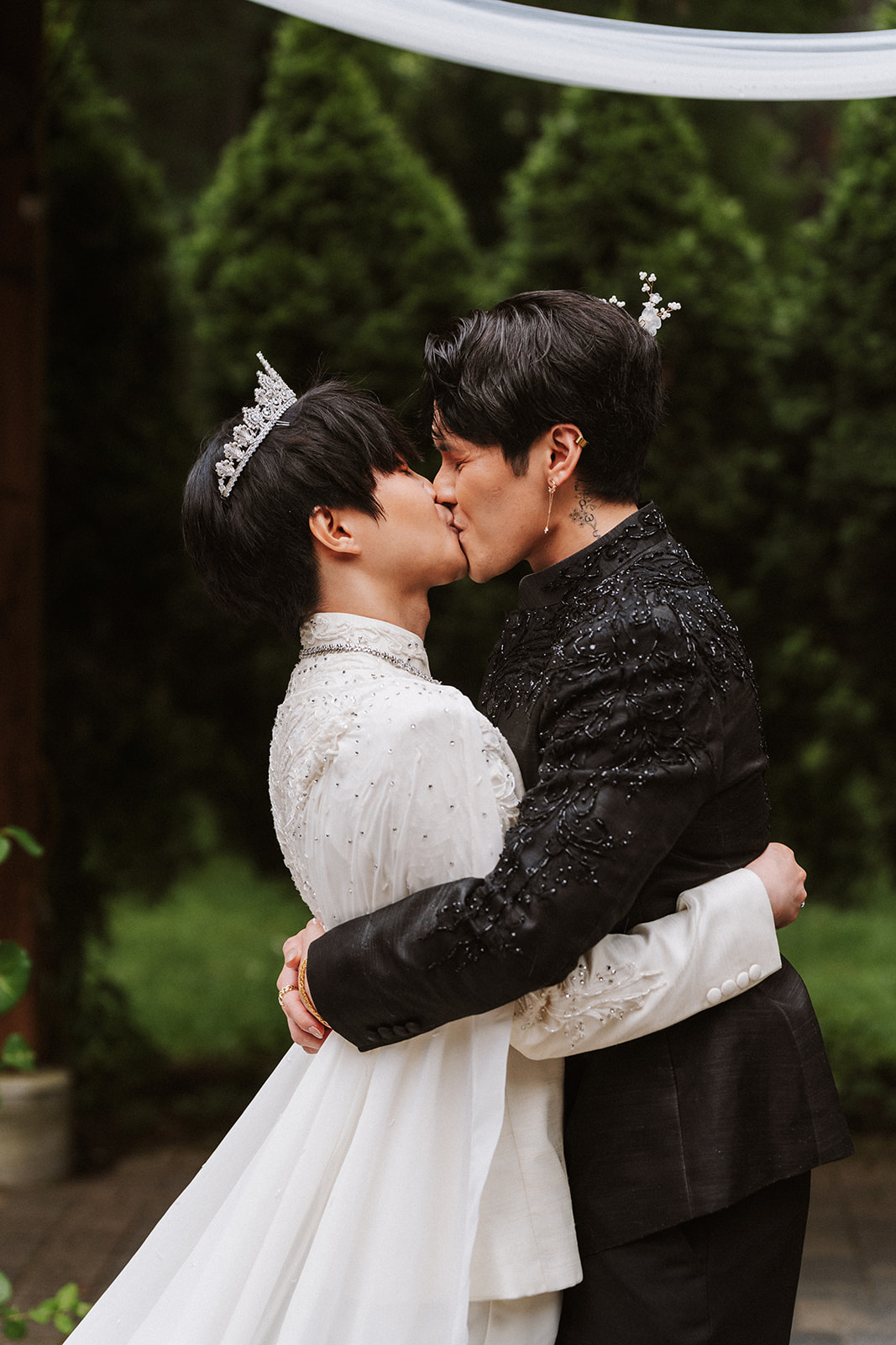 James and Andrew's first kiss beneath a draped garden canopy