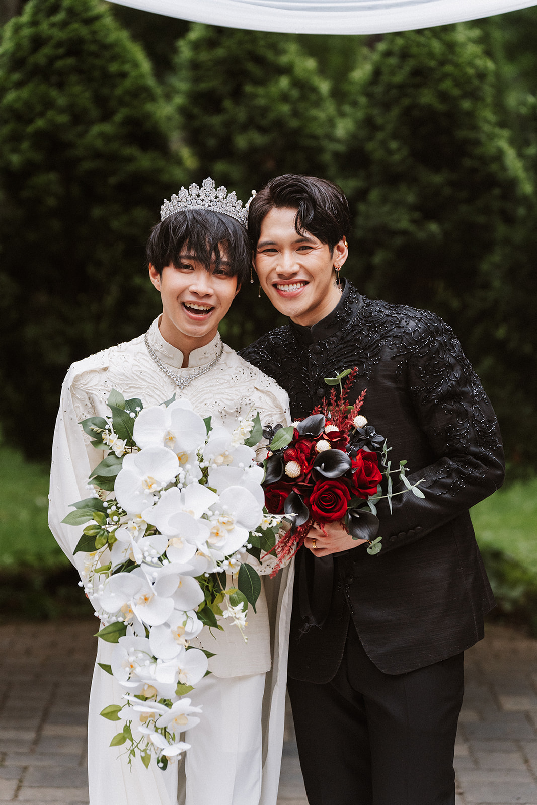 James and Andrew together after their ceremony holding orchid and rose bouquets