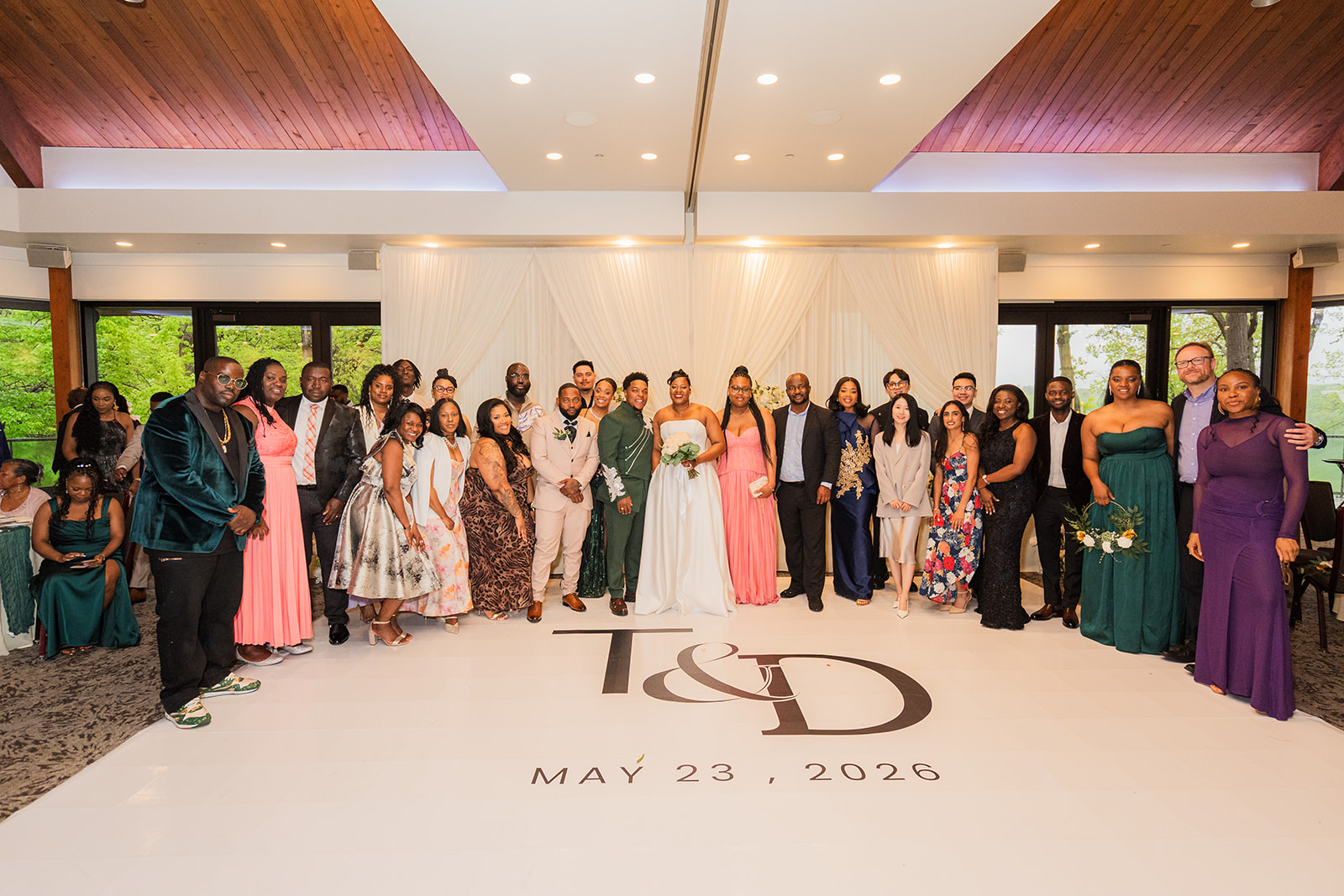 TJ and Deval with their full wedding party on a monogrammed dance floor
